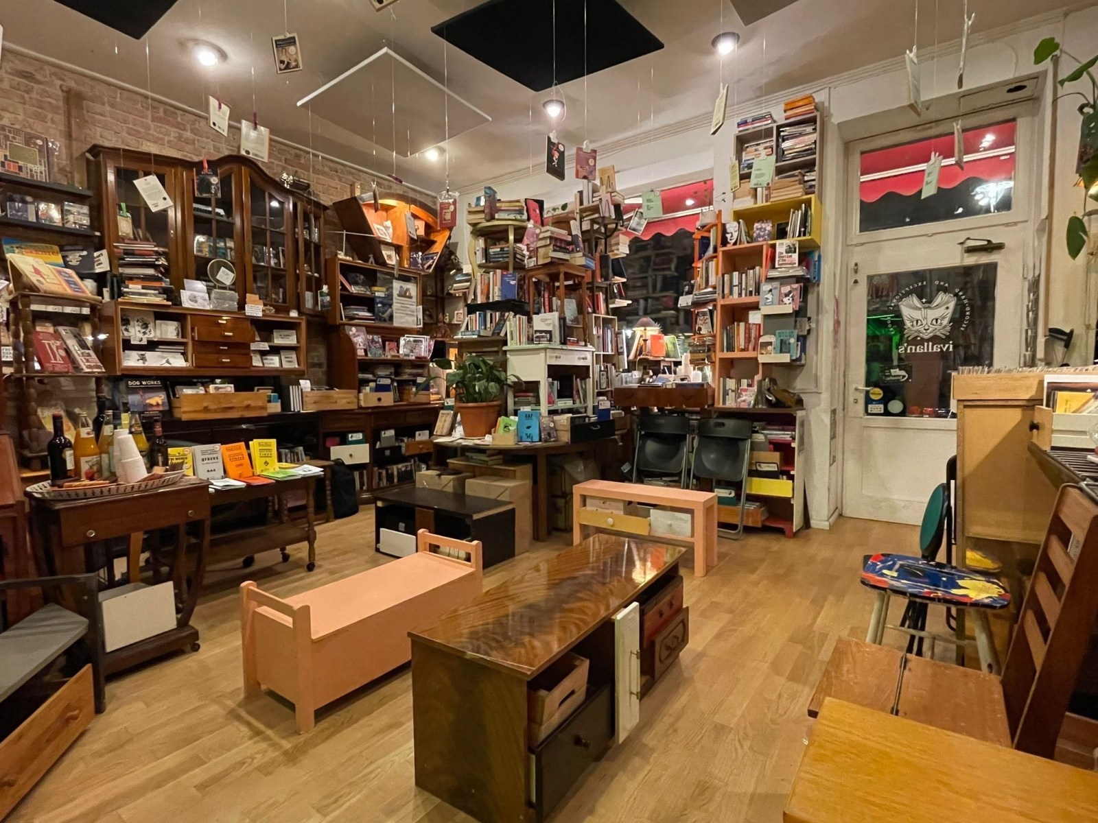 An image of the bookshop with book shelves lining the walls and various tables and bench seats scattered around.